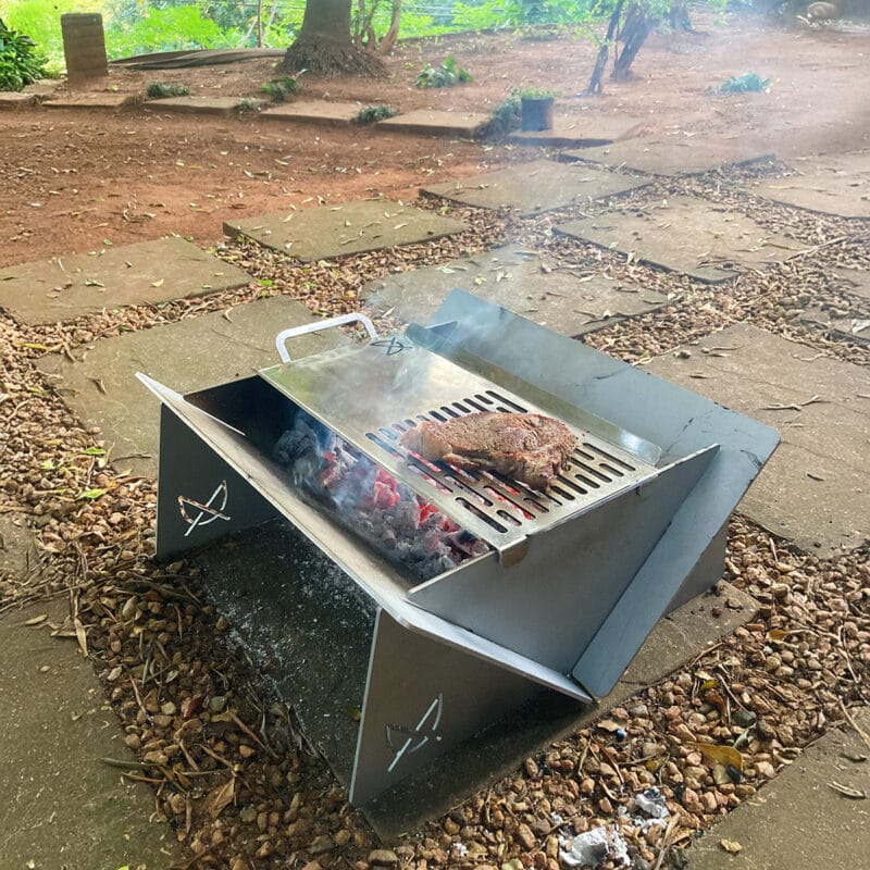 Stainless Steel Fire Pit Grill-Skillet with some meat on the Grill